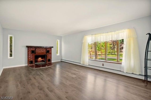 unfurnished living room featuring wood finished floors, baseboards, and a brick fireplace