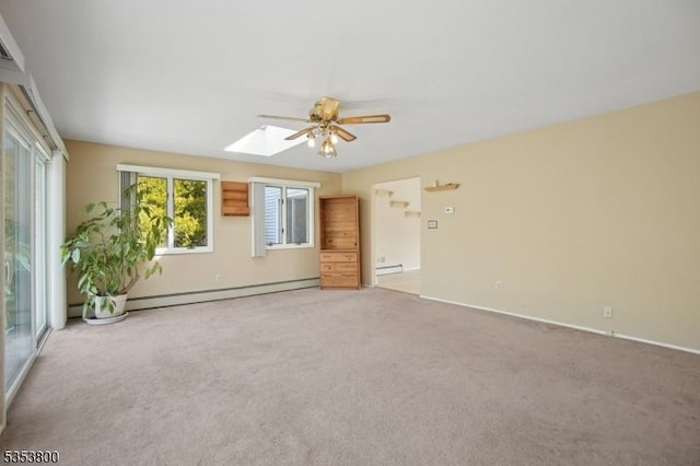 empty room featuring ceiling fan, a skylight, light carpet, baseboards, and a baseboard heating unit