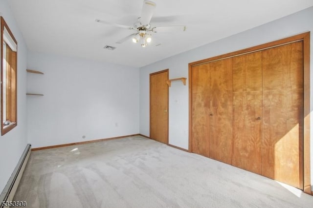 unfurnished bedroom with a baseboard radiator, carpet flooring, baseboards, a ceiling fan, and a closet