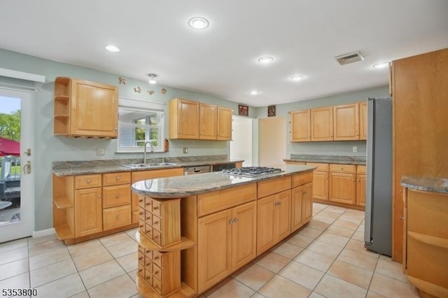 kitchen with open shelves, a sink, appliances with stainless steel finishes, a kitchen island, and light stone countertops
