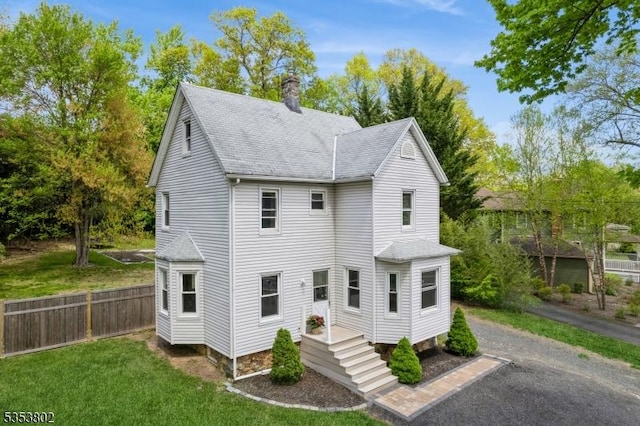 590 Valley Rd, Long Hill Twp, NJ 07933 - rear view of house featuring a chimney, a shingled roof, fence, and a lawn