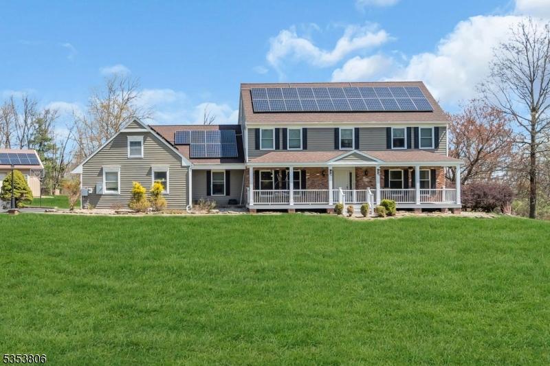 4 Laurelton Trl, Raritan Twp, NJ 08822 - back of house with a porch, a shingled roof, a yard, and solar panels