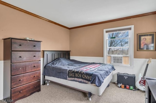 carpeted bedroom featuring cooling unit, ornamental molding, and a wainscoted wall