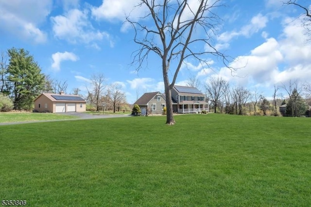 exterior space with a detached garage and aphalt driveway
