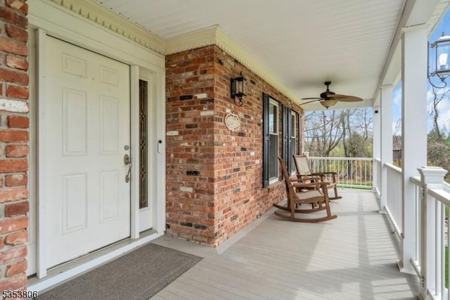 exterior space featuring covered porch, brick siding, and a ceiling fan