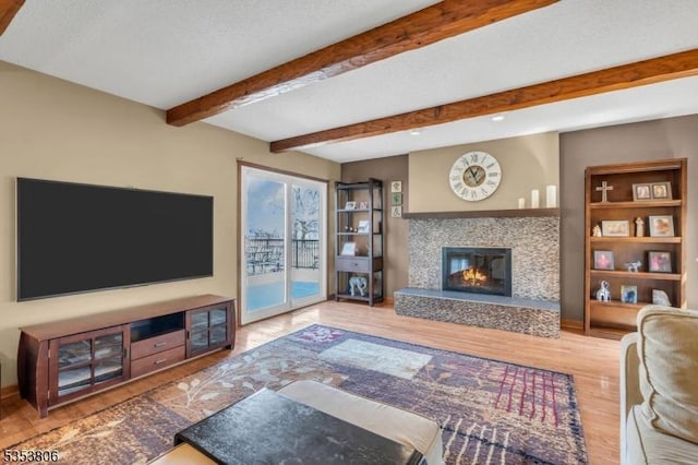 living room with recessed lighting, wood finished floors, a premium fireplace, and beamed ceiling