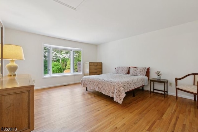 bedroom with baseboards and light wood finished floors