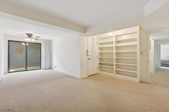 carpeted empty room featuring baseboards and a ceiling fan