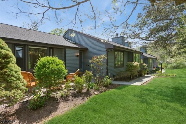 view of home's exterior with a yard and a chimney