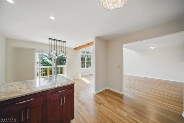 kitchen featuring open floor plan, an inviting chandelier, and light wood-type flooring