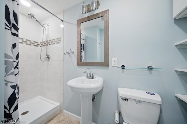 full bathroom with a sink, baseboards, a stall shower, and toilet
