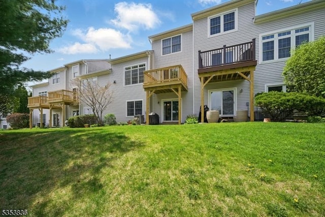 rear view of house featuring a yard and a balcony