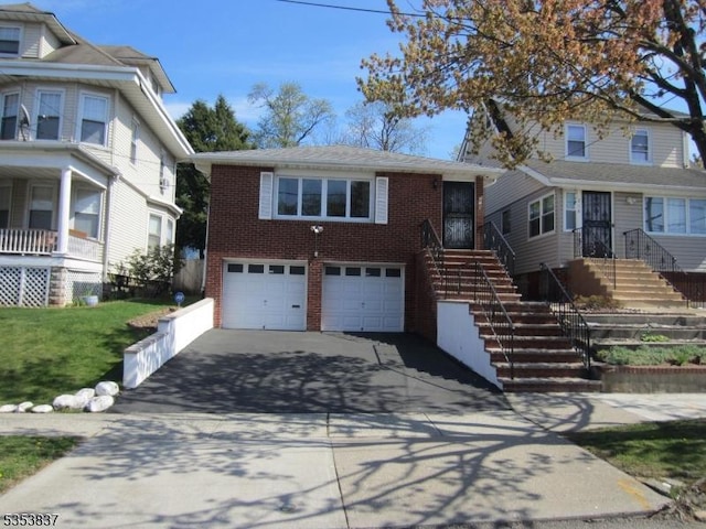 view of front of house featuring brick siding, an attached garage, driveway, and a front lawn