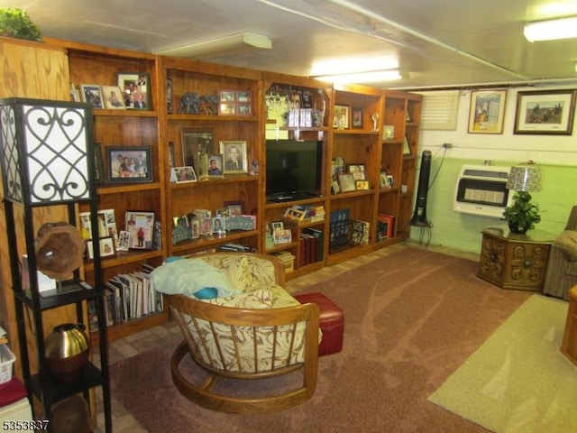 sitting room with heating unit, carpet floors, and wooden walls