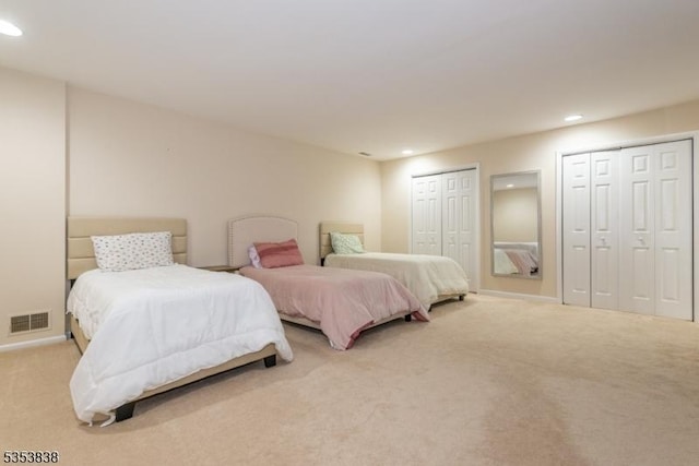 carpeted bedroom with two closets, recessed lighting, baseboards, and visible vents