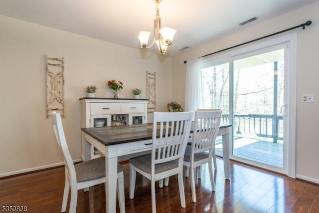 dining space with baseboards, visible vents, dark wood-style floors, and an inviting chandelier