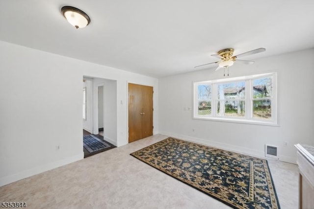 foyer with visible vents, baseboards, ceiling fan, and carpet floors