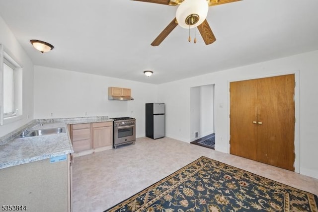kitchen with a ceiling fan, appliances with stainless steel finishes, a sink, light countertops, and under cabinet range hood