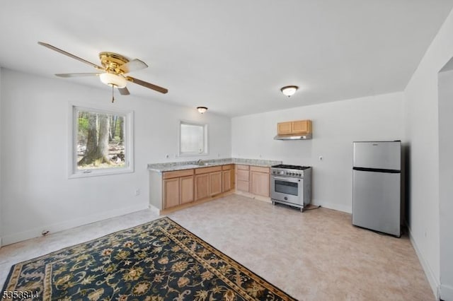 kitchen featuring light brown cabinetry, baseboards, light countertops, a ceiling fan, and stainless steel appliances