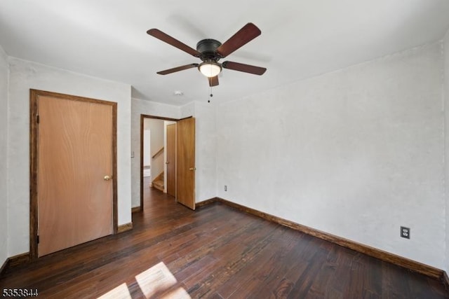 unfurnished bedroom featuring baseboards, a ceiling fan, and dark wood-style floors