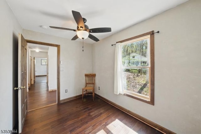 unfurnished room featuring dark wood-style flooring, baseboards, and ceiling fan