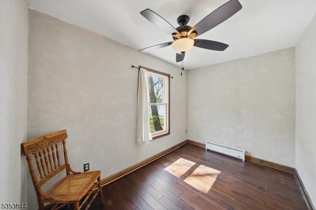 unfurnished room featuring a ceiling fan, baseboards, a baseboard heating unit, and hardwood / wood-style flooring