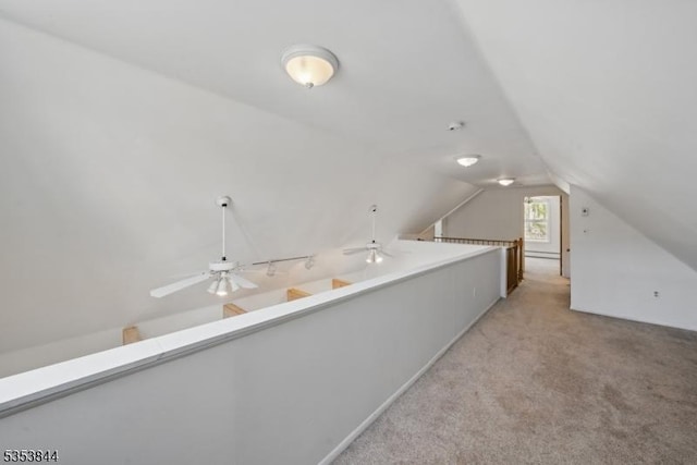 additional living space with light colored carpet, a ceiling fan, and vaulted ceiling