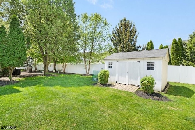 view of yard with an outbuilding, a storage shed, and a fenced backyard