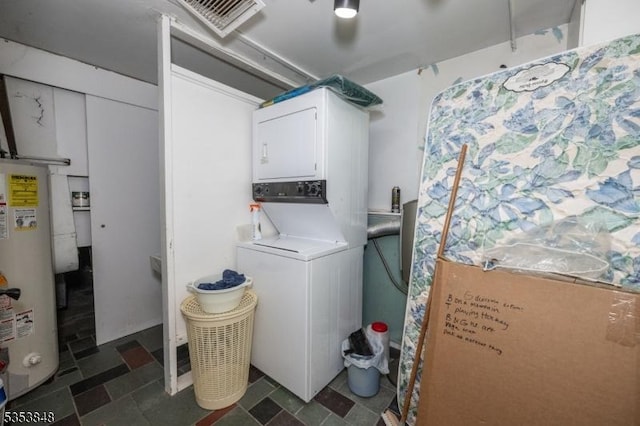 clothes washing area with water heater, visible vents, laundry area, and stacked washer and clothes dryer
