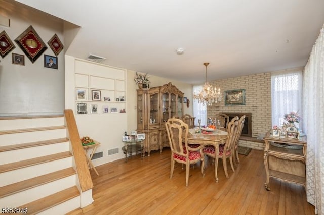 dining space featuring visible vents, light wood finished floors, and a notable chandelier