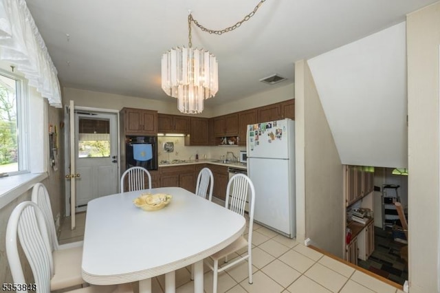 dining space featuring visible vents, light tile patterned flooring, and a notable chandelier