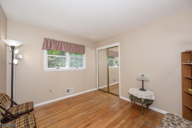 unfurnished bedroom with baseboards, a closet, light wood finished floors, and visible vents