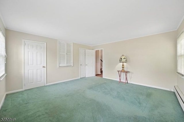empty room featuring carpet flooring, baseboards, and baseboard heating