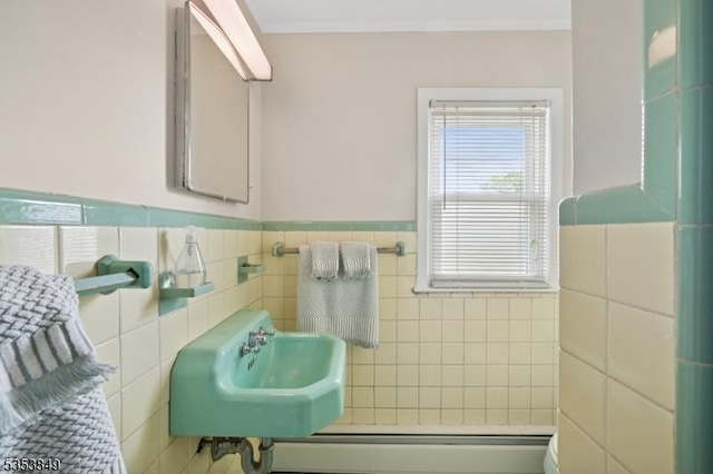 bathroom featuring a sink, tile walls, and wainscoting