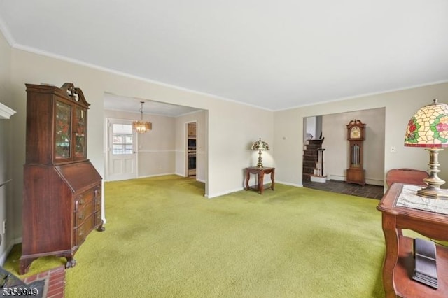 living room with baseboards, ornamental molding, carpet, and a chandelier