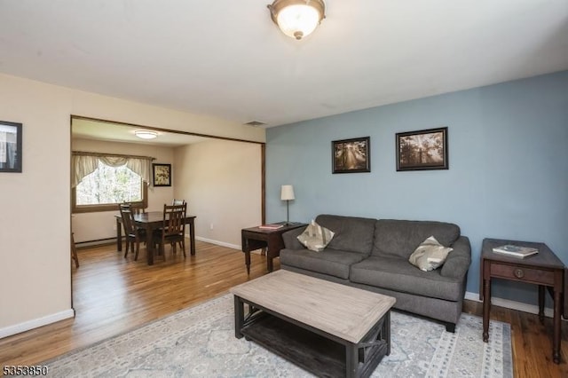 living area with baseboards and light wood-style flooring