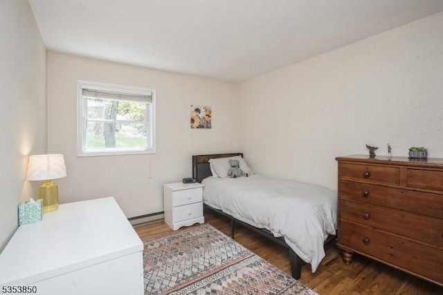 bedroom with a baseboard radiator and wood finished floors