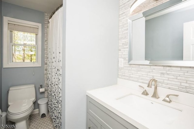 bathroom featuring vanity, backsplash, toilet, and curtained shower