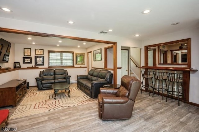 living room with visible vents, wood finished floors, baseboards, stairway, and recessed lighting