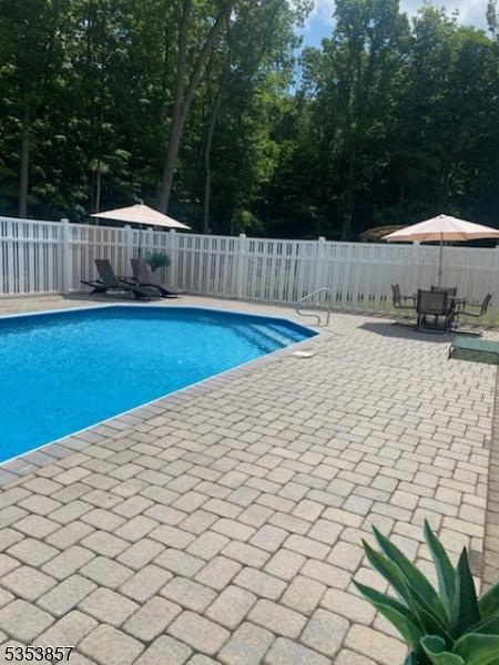 view of pool with outdoor dining space, a fenced in pool, a fenced backyard, and a patio area