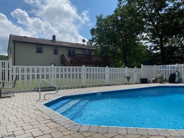 view of pool featuring a fenced in pool, a wooden deck, a fenced backyard, and a patio
