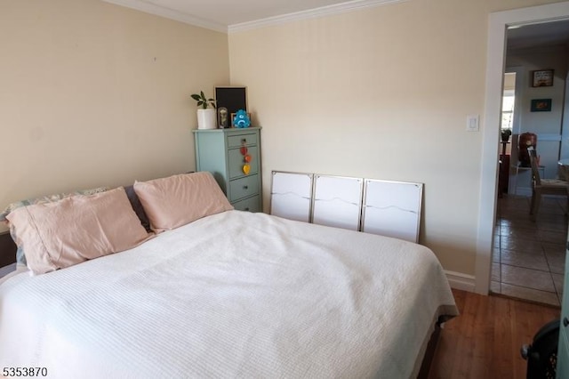 bedroom featuring crown molding, baseboards, and wood finished floors