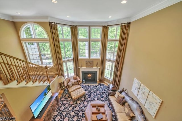 28 Arbor Rd, North Caldwell Boro, NJ 07006 - living area featuring ornamental molding, recessed lighting, a warm lit fireplace, stairway, and a high ceiling