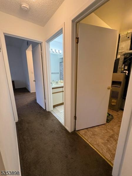 corridor featuring carpet floors and a textured ceiling