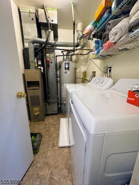 laundry room featuring washing machine and clothes dryer, laundry area, and gas water heater