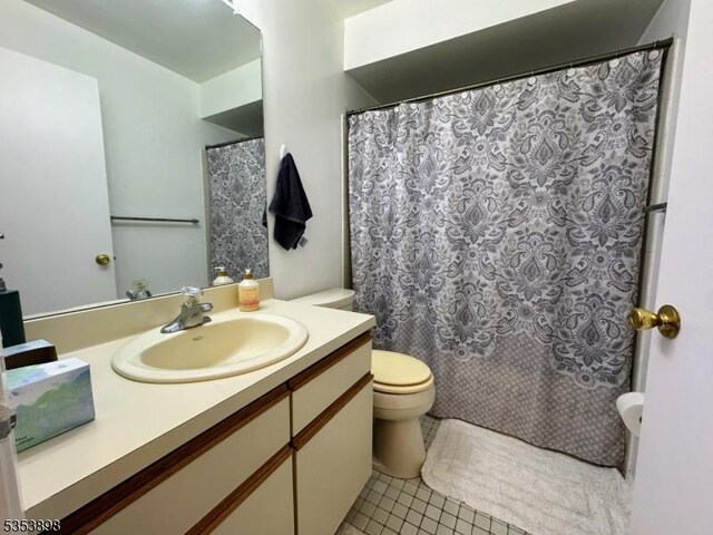 bathroom with vanity, tile patterned flooring, and toilet