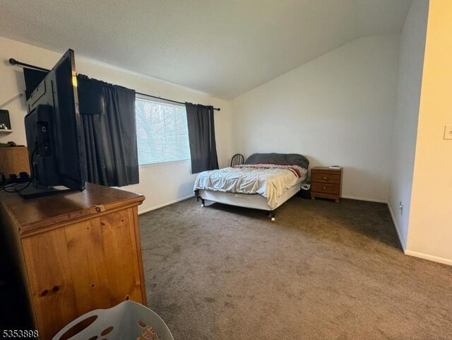 carpeted bedroom with baseboards and vaulted ceiling