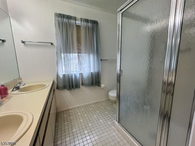 bathroom featuring tile patterned floors, a shower stall, and a sink