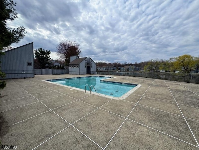 community pool featuring a patio area and fence