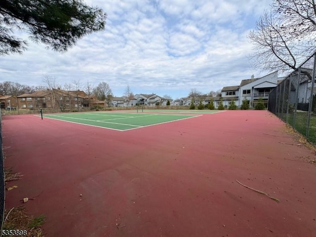 view of sport court featuring fence and a residential view